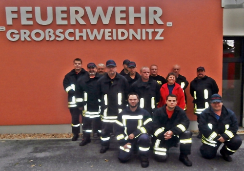 Feuerwehrmänner vor Feuerwehrgebäude